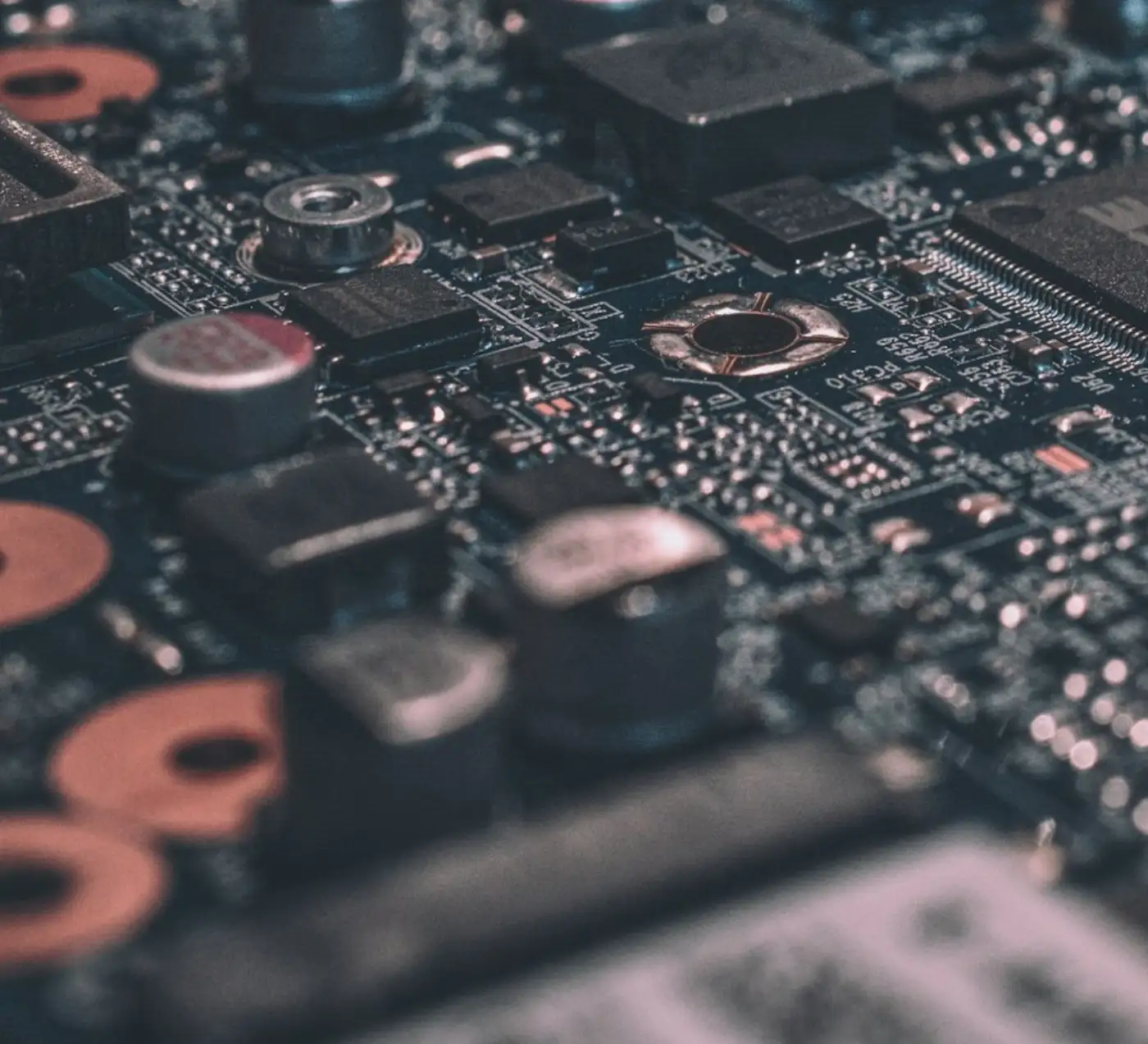 Close-up of circuit board components and copper traces on dark IT hardware